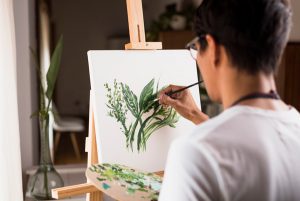 Hombre dedicando tiempo para sí mismo pintando un cuadro como propósito saludable para el 2021